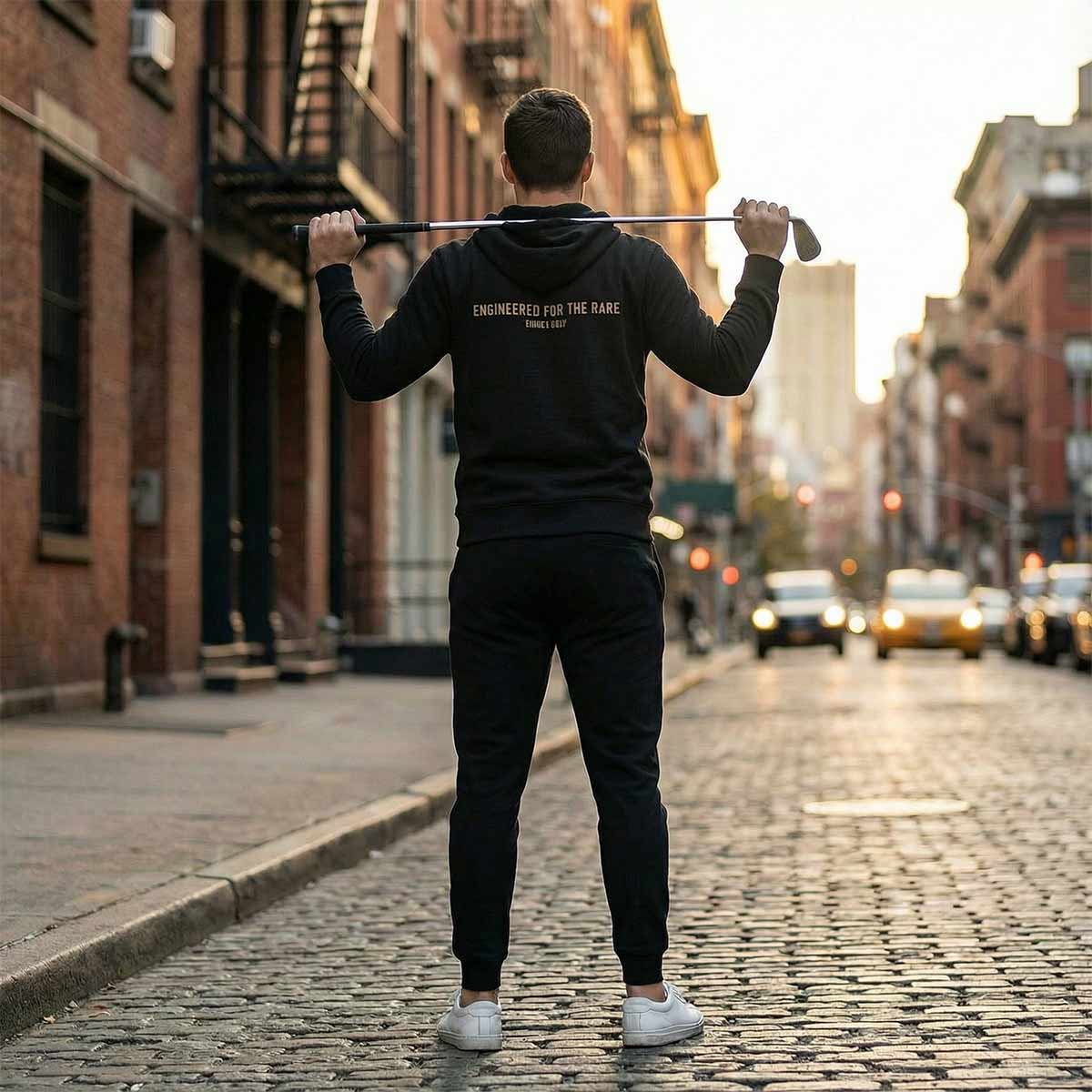 Golfer Craig wearing the Rare Hoodie in black, standing on a city street.