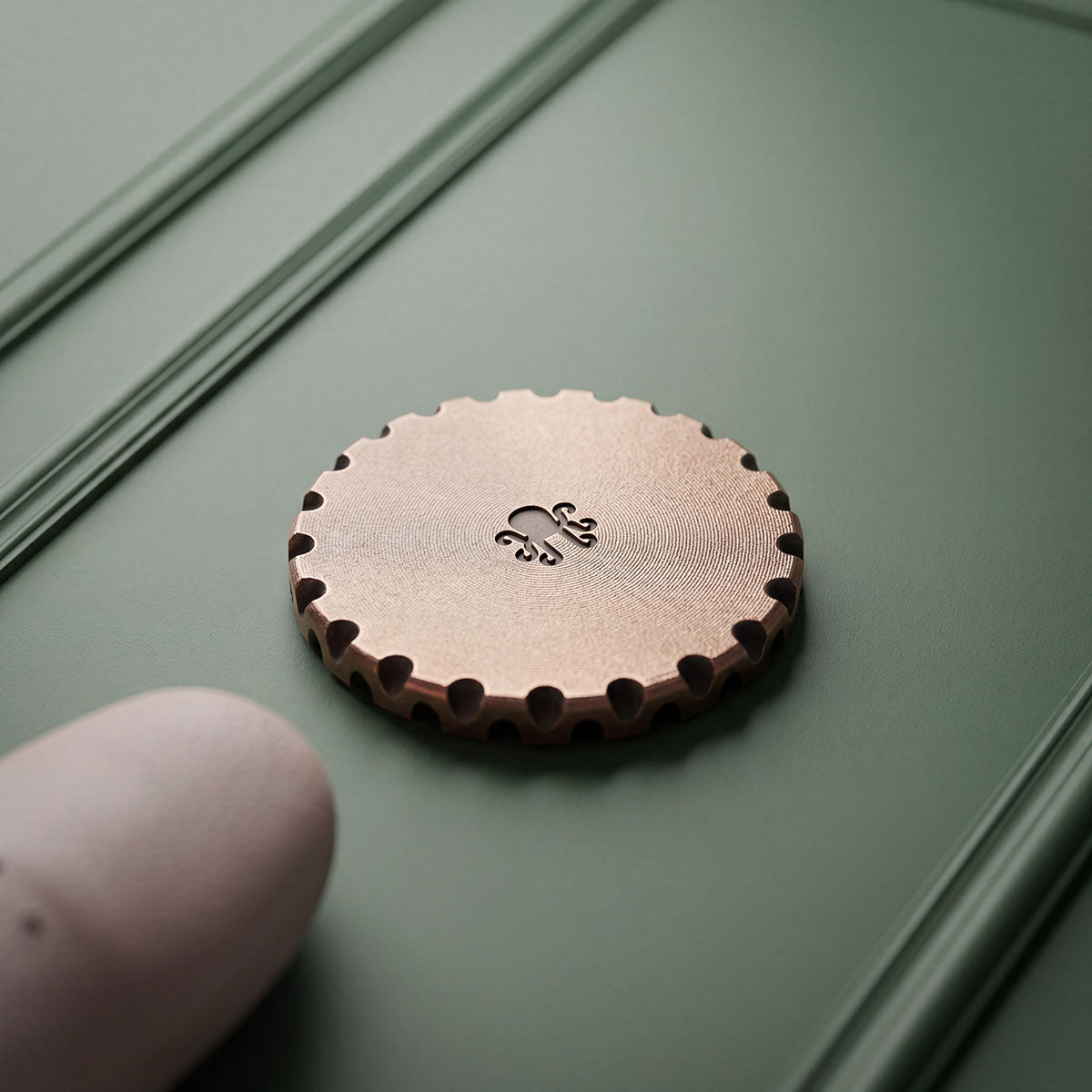 Back of The Reckoning golf ball marker showing darkened Kraken octopus logo on copper - Kraken Golf Blacklist exclusive