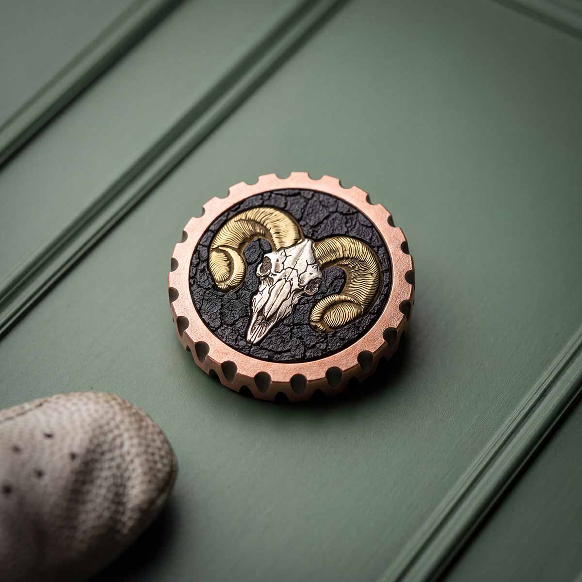 Milled copper golf ball marker with cracked earth inlay, brass horn inlays and stainless steel ram skull - The Reckoning by Kraken Golf