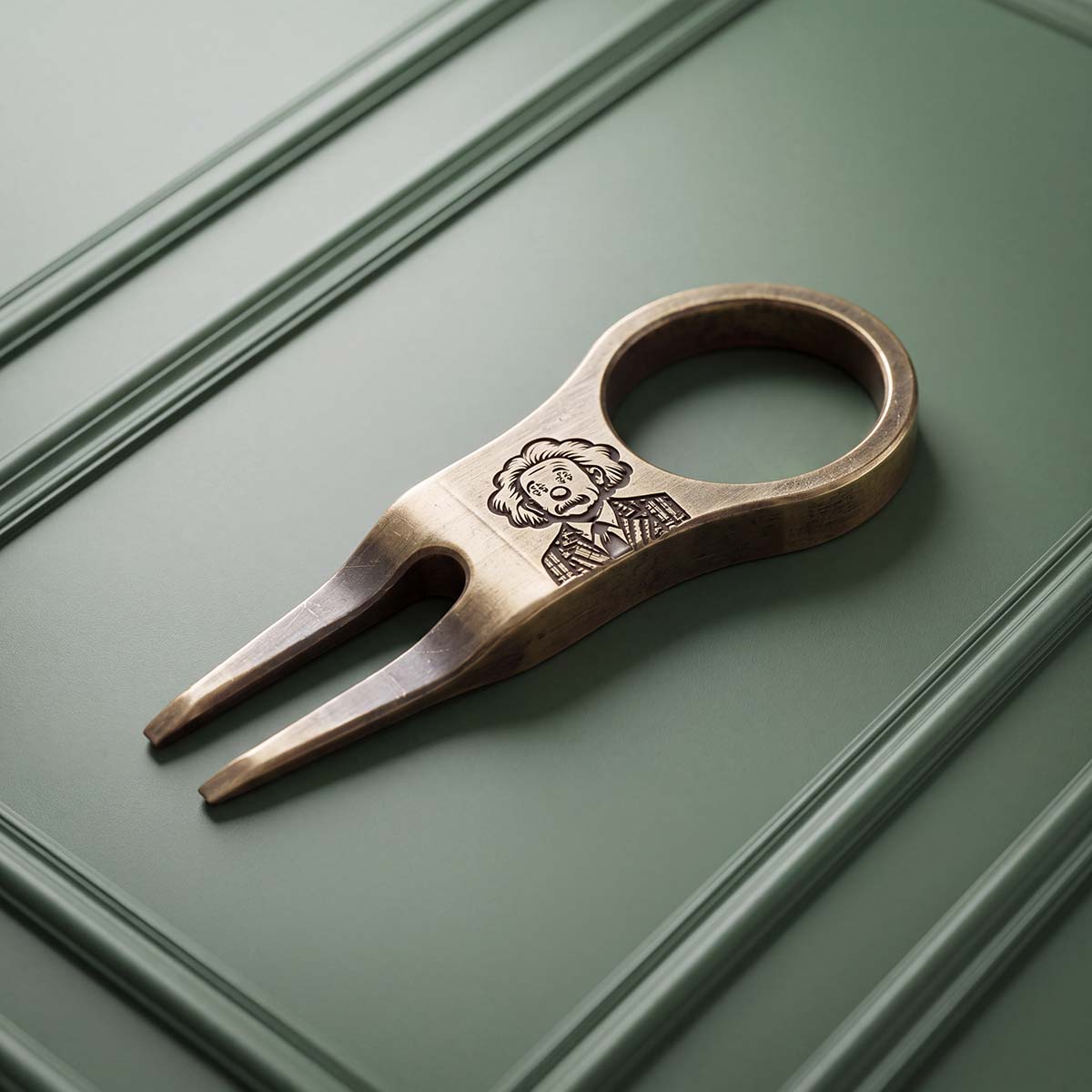 THEORY brass pitch tool by Kraken Golf with laser-engraved wild-haired portrait on aged bronze finish