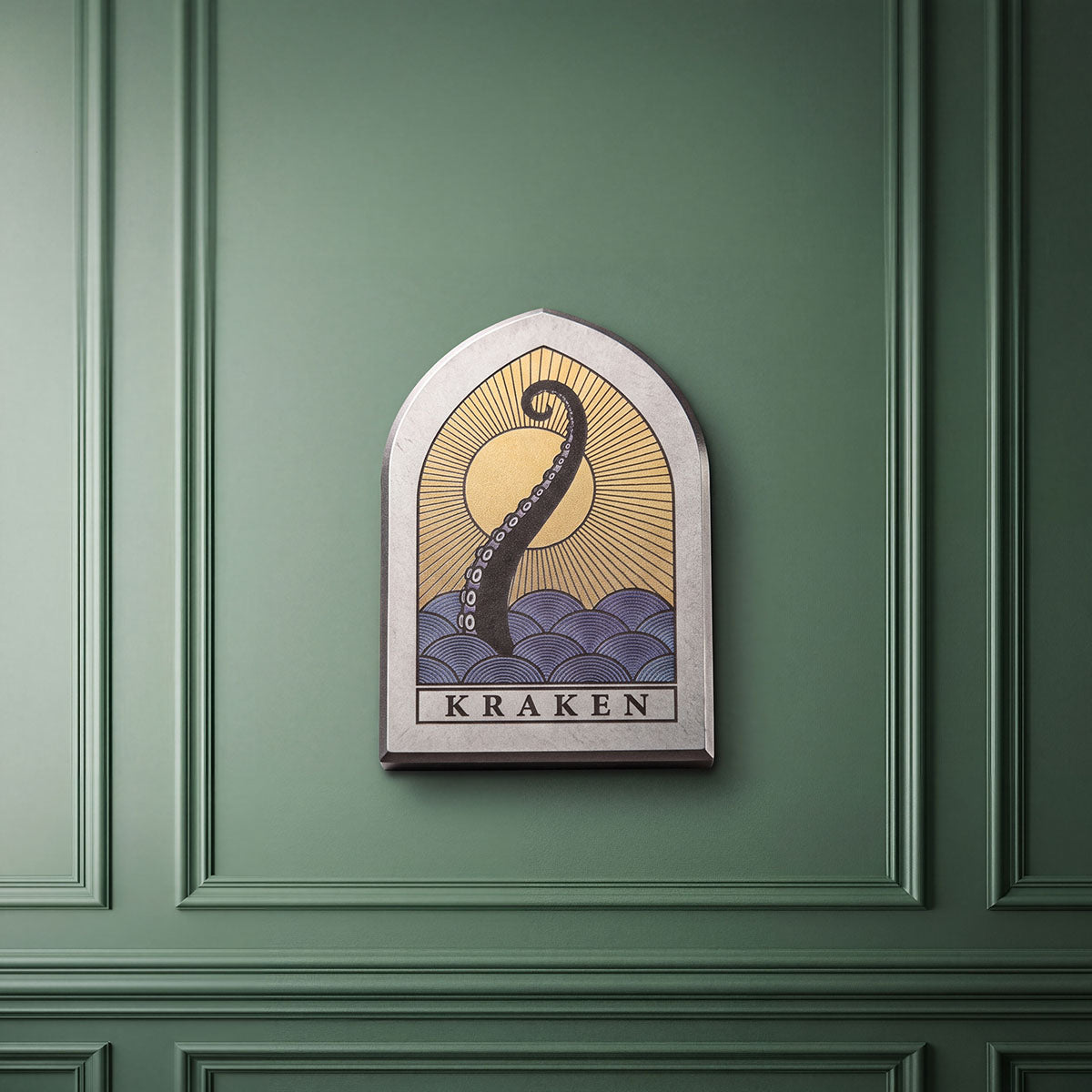 The Vesper titanium golf ball marker front view, stained glass window shape with Kraken ocean sunset artwork by Kraken Golf
