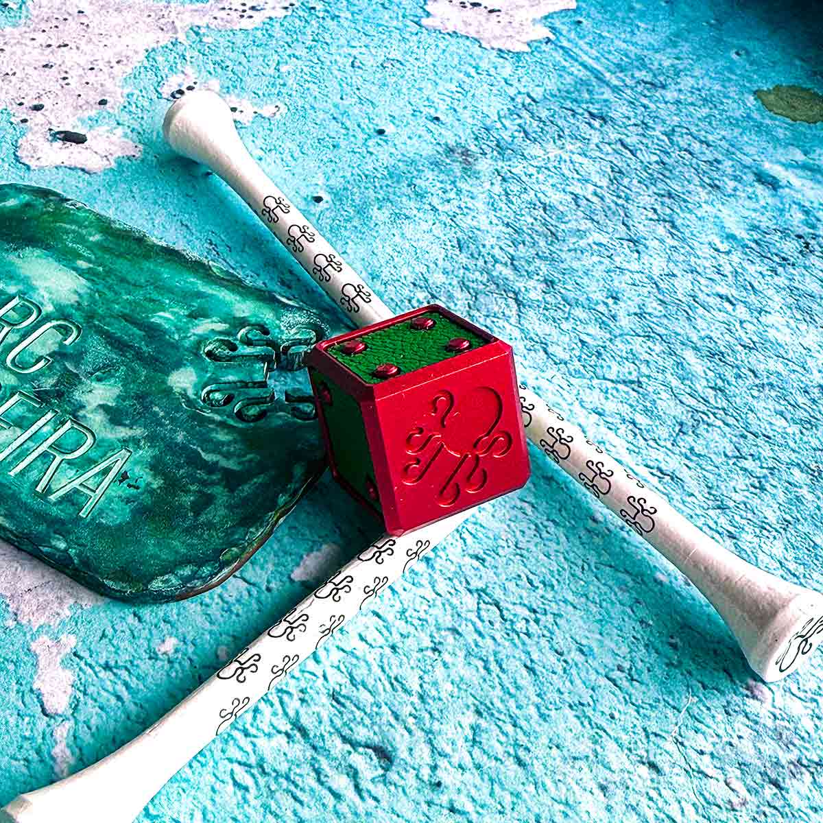Watermelon golf ball marker cube with hot pink anodized finish and lime green leather inlays